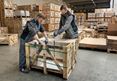 Deux employés emballent une boîte avec pierres