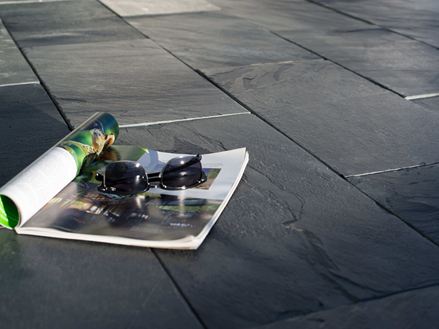 Magazine et lunettes de soleil sur terrasse en ardoise au soleil