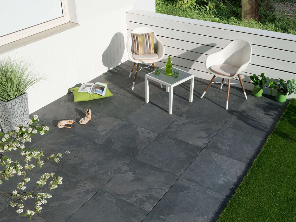 Terrasse avec mobilier moderne et dalles gris foncé imitation ardoise vues d'en haut.