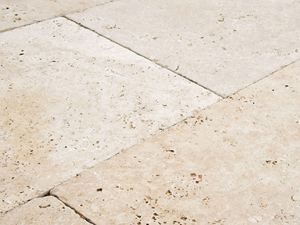 Gros plan sur le dallage de terrasse en travertin Medium Select en beige tendre