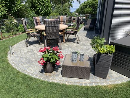 Les pavés en gneiss Urban Grey Line dans le jardin avec des fleurs
