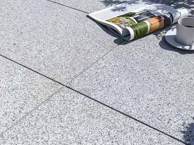 Dalles de terrasse en granite Silver Classico avec magazine et tasse de café