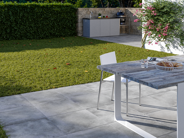 Terrasse avec dallage effet béton Ombra 3 cm avec table et cuisine extérieure