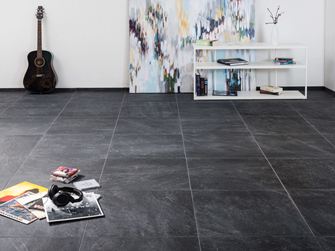 Carreaux modernes en grès cérame porcelainé d'aspect ardoise dans un salon avec une peinture moderne à l'arrière-plan et une guitare au mur.