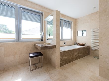 Une salle de bain élégante dans laquelle le travertin Classic Light a été posé au sol et au mur