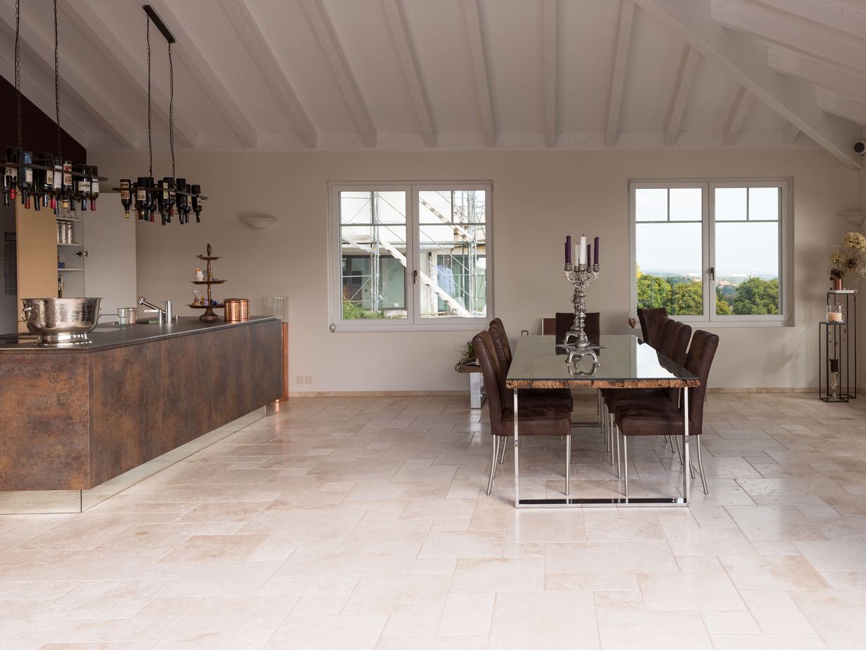 Les carreaux de travertin Light en format opus romain dans une cuisine moderne avec table et îlot