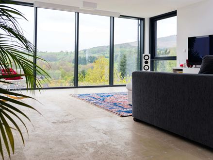 Salon avec carrelage en travertin Medium Line et grande baie vitrée