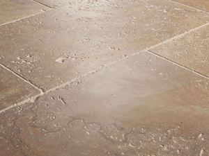 Gros plan sur le carrelage en travertin Noce