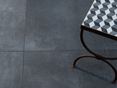 Un style urbain créé par la surface effet béton. Les carreaux anthracite effet béton Pure Graphite et une table.