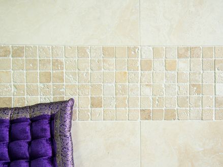 Mosaïque en travertin, entouré de revêtement mural travertin avec coussin violet