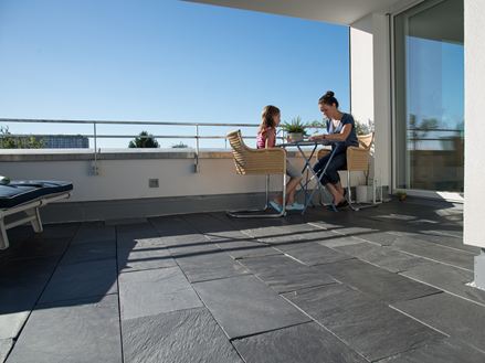 Femme et enfant assis à une table sur la terrasse du toit en ardoise naturelle