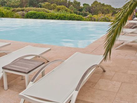 transat au premier plan puis piscine et mer