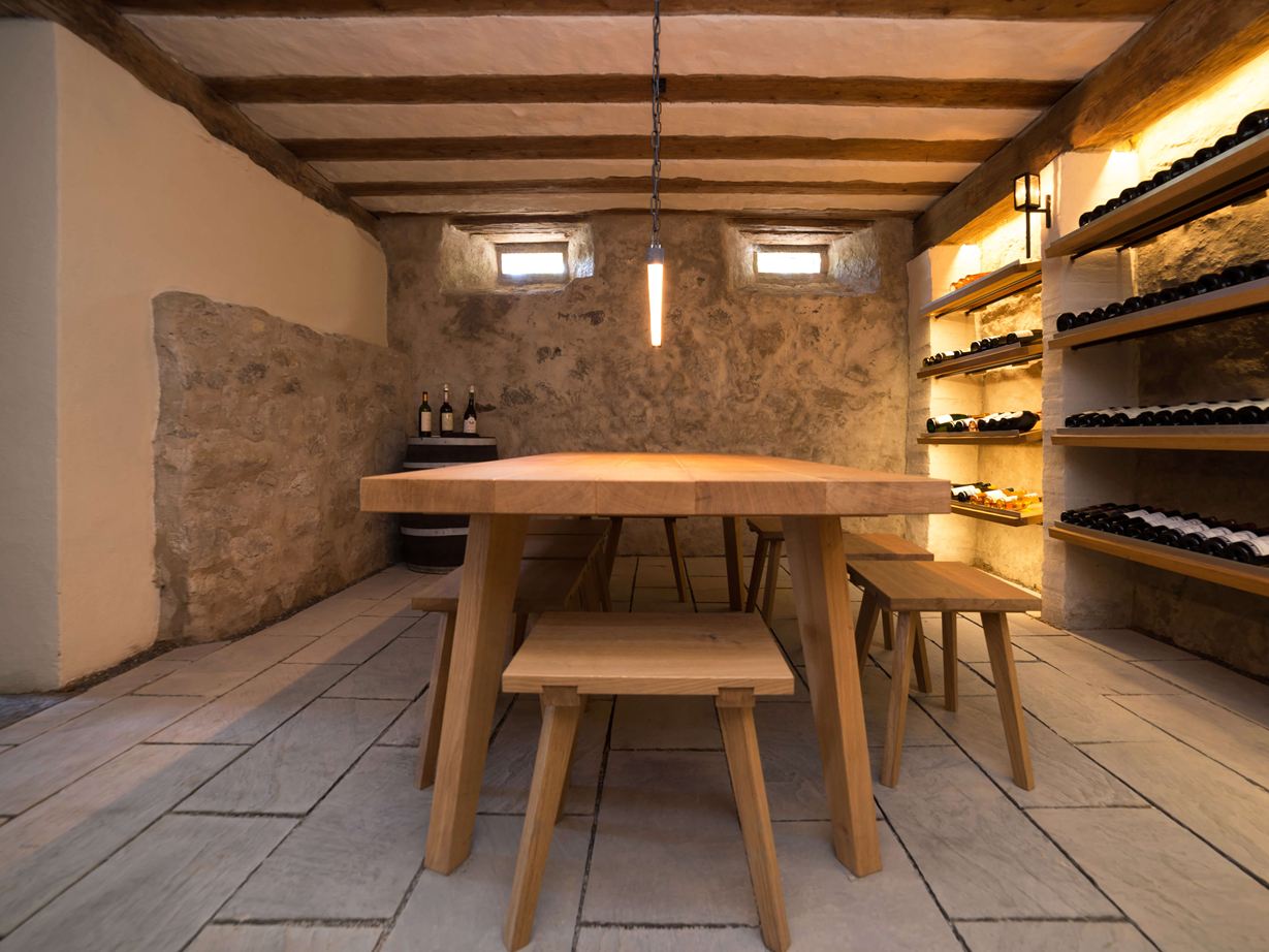 Cave à vin avec une grande table en bois et la pierre naturelle Kandla Grey en grès