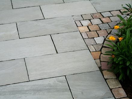 Kundenfoto: Sandstein-Platten Kandla Grey neben gelben Blüten
