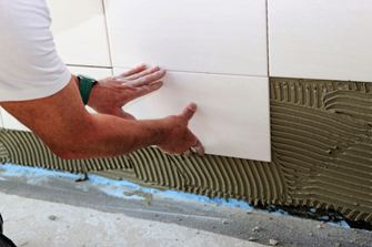 Mit sanftem Druck schieben Sie die Wandfliesen in das Kleberbett ein